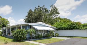 home with large plants and grassy lawn